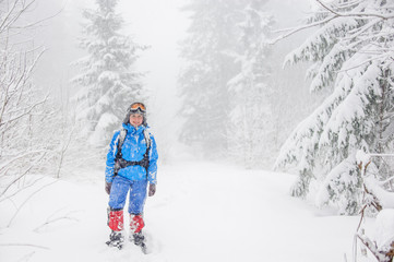 Girl tourist standing in a blizzard in the mountains