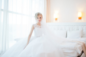 gentle blonde  bride on couch tenderly posed