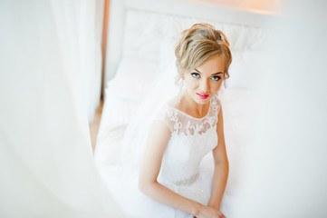 Fototapeta na wymiar gentle blonde bride on couch tenderly posed