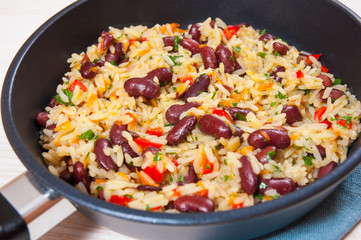 Rice with red beans and vegetables in a frying pan