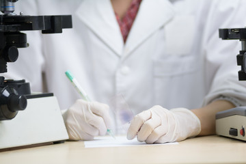 scientist hold slide in left hand and write something down on pi