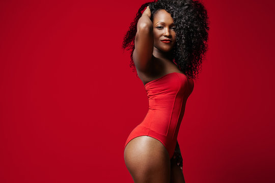 woman wearing red body suit on a red background