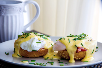 Eggs Benedict- toasted muffins, ham, poached eggs, and delicious buttery hollandaise sauce © proxima13