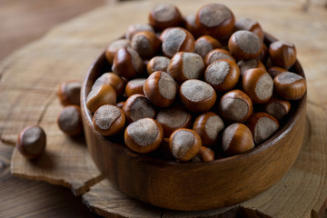 Close-up of hazelnuts in a wooden bowl, selective focus