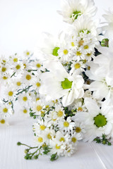 Obraz premium White daisy bouquet on white wood background