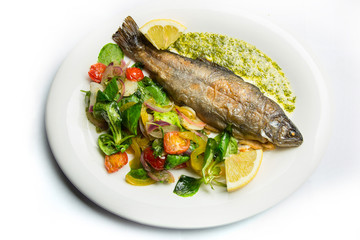 Baked fish sea bass with garlic sauce and vegetables