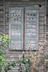 verschlossener Fensterladen an einem alten Holzhaus
