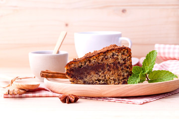Homemade dark chocolate cake with cup of coffee on wooden backgr