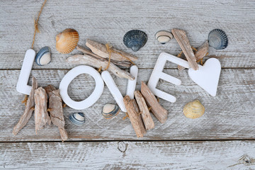 old white wooden shelves background with beach sea shells and love letters and heart shape