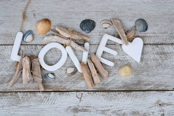 old white wooden shelves background with beach sea shells and love letters and heart shape
