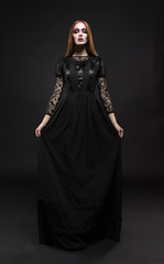 Portrait of gothic girl with black eyes in dark clothes