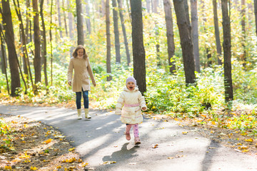 Fototapeta premium Mother and daughter walking in the autumn park