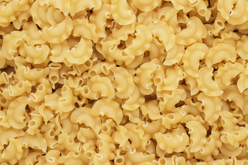 dry uncooked creste di galli pasta texture background