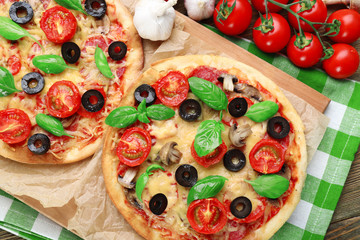 Tasty pizza with vegetables and basil on table close up