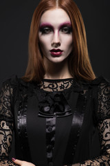 Portrait of gothic girl with black eyes in dark clothes