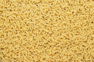 dry uncooked rotini texture background