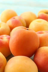 Heap of ripe apricots on wooden table close up