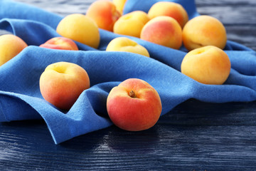Ripe apricots with napkin on wooden table close up