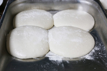 Fototapeta na wymiar Preparing pizza dough in metal pan, closeup