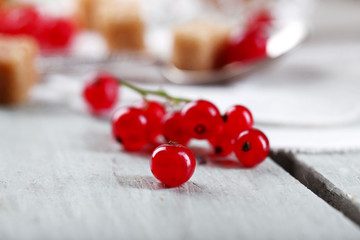 Fresh red currants with sugar on table close up