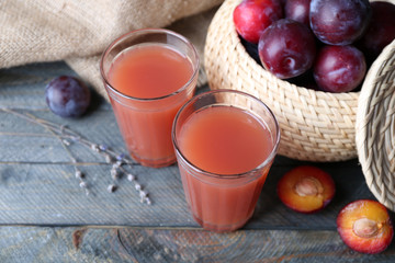 Delicious plum juice with fruits on wooden table close up © Africa Studio