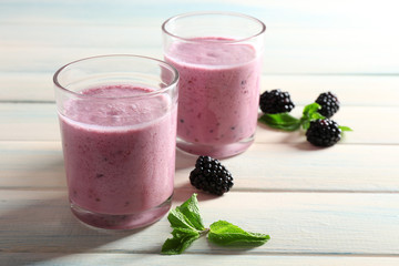 Delicious berry smoothie with blackberries on wooden table close up