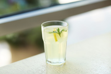 Glass of lemonade on blurred background