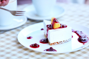 Delicious cheesecake with sauce on table in cafe