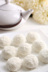 Homemade coco sweets on plate, on light background