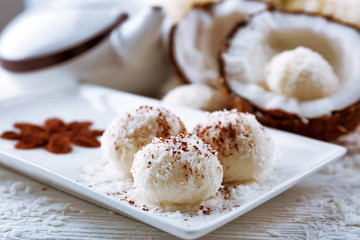 Homemade coco sweets on plate, on light background