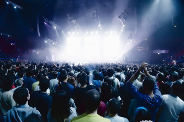 concert crowd of young people in front of bright stage lights