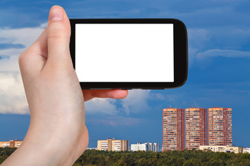 smartphone and dark blue sky over urban houses
