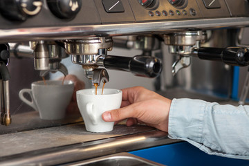 Professional male worker is making espresso in cafeteria