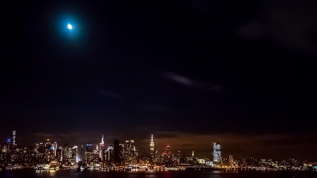 Timelapse with the first phase of a lunar eclipse and clouds invading the midtown Manhattan sky.