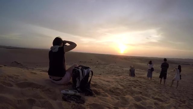 A Girl take a photo of sunrise at White Sand Dune in Vietnam