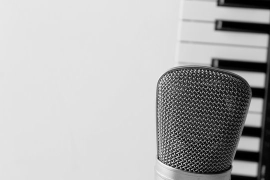 Microphone and blurred piano keys on background