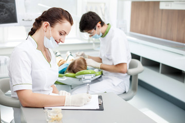 Obraz na płótnie Canvas Cheerful young dentist is examining human oral cavity