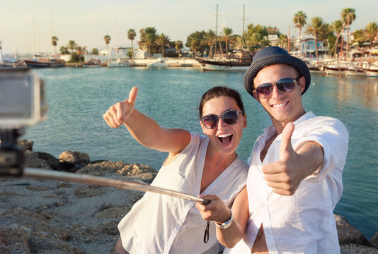 Positive young couple take a selfie photo in tropical harbor