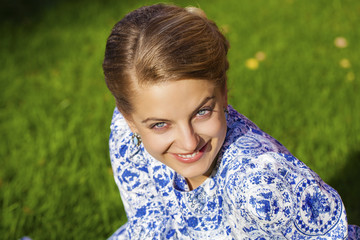 Portrait of young blonde woman in blue dress