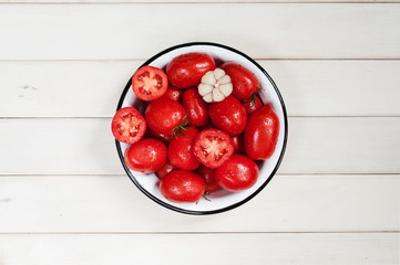 Ripe tomatoes and garlic in the white bowl