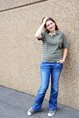 Female tomboy expressions against a wall outside.