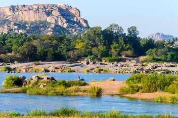 Fotobehang Picturesque tropical landscape in Hampi, India. Tungabhadra River in Hampi area with Anjaneya hill in the background which is believed to be the birthplace of Hindu God Hanuman. © David Bokuchava