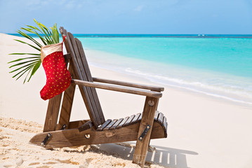 Sun lounger with Santa sock at beautiful tropical beach with whi