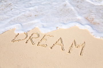 Word DREAM on beach - vacation concept background
