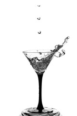 Cocktail glass with splashes on white background.