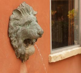 Statue of lion heads spout water.