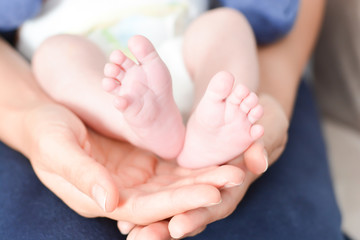 Mother holding baby feet in her palms suggesting parenting affection or love