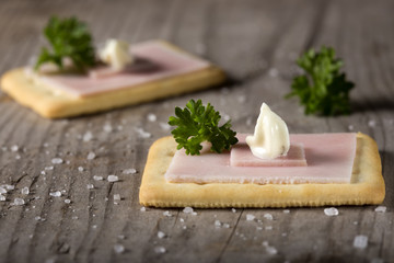 Crackers with ham and roumulade sauce