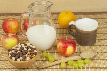 Chocolate cereal balls in a bowl of bamboo. Healthy breakfast with fruit and milk. A diet full of energy and fiber for athletes. Quick to prepare homemade breakfast.
