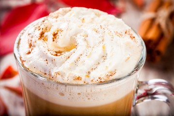 pumpkin latte with whipped cream in a glass jar closeup